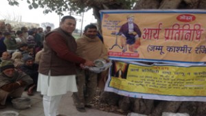 A representative of Arya Pratinidhi Sabha, J&K giving a steel utensils to a flood affected people at Pargwal sector in Jammu.