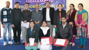 Winners of Seminar displaying merit certificates while posing for a group photograph along with the chief guest and other dignitaries at Udhampur on Saturday.  