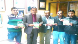 Former Minister Sham Lal Sharma flanked by others releasing book on fruit production in Jammu on Friday.