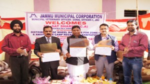 MLA Jammu West, Sat Sharma and officers of JMC releasing pamphlets having contact number of sanitation staff, during a camp at Jammu on Monday.