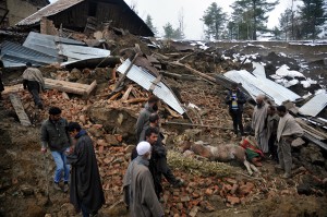 Villagers watching a collapsed house at the site of a landslide at village Laden in Budgam district on Monday. More pics on page Nos. 3 & 6.   —Excelsior/Amin War
