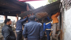 Enforcement staff of JMC demolishing an illegal structure near Canal Head at Jammu.