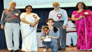 Minister for Education Naeem Akhtar and Minister of State for Education, Priya Sethi posing for group photograph after presenting trophy to meritorious students at GCW Gandhi Nagar in Jammu.