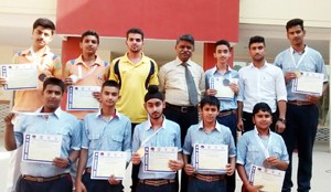 Medal winning students of GD Goenka Public School displaying certificates while posing for a group photograph in School premises.   
