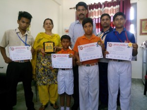 Medal winners of J&K Police Public School  displaying certificates while posing for a photograph along with Principal  Sanjeev Pradhan. 