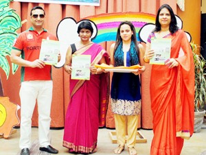 Vice chairman and Principal of KCIS displaying newsletter of the school.