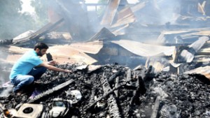 A man searches for his important documents from debris after his office destroyed  in  a major fire in National Conference Nawai-e-Subh shopping complex in Zero Bridge area in Srinagar on Sunday.     -Excelsior/Amin War