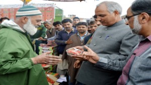 Minister for Horticulture, Abdul Rehman Veeri interacting with traders and fruit growers during his visit to Parimpora on Monday.