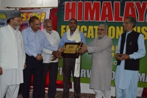 An artist being felicitated during art camp at Rajouri on Thursday.
