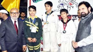 Medal winners posing for photograph with Education Minister Naeem Akhtar at Srinagar on Thursday.