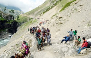 Some pilgrims take rest as others continue their journey towards holy cave. — Excelsior/Sajad Dar