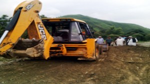 Villagers of Rajdhani in Thannamandi area of Rajouri supervising road repair work. 