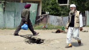 Pedestrian walks over an uncovered manhole in Baramulla town. —Excelsior/Aabid Nabi