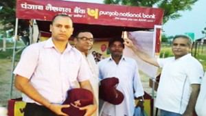 PNB Circle Head BM Fazili and others distributing caps among Amarnath pilgrims at Jammu on Friday.