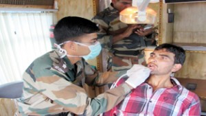 Doctor examining a patient during medical camp at Dudbhug village in district Baramulla on Wednesday.  -Excelsior/Aabid Nabi