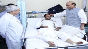Union Home Minister, Rajnath Singh interacting with a Constable of Jammu and Kashmir Police, Mohammad Salim who is undergoing treatment at AIIMS, New Delhi on Saturday. (UNI)