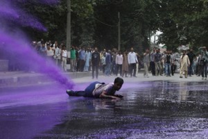 Police spraying water on agitating PHE daily rated workers in Srinagar on Monday. 