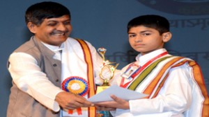 Prof P N Shastri giving prize and certificate to a meritorious student during Annual Day of SMVD Gurukul on Monday. 