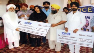 Mahant Manjeet Singh distributing cheques among police firing victims of  Gadigarh during function at Digiana Ashram  on Sunday.