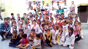 Medal winners of District Taekwondo Championship organized by Academy of Sports posing for a group photograph alongwith chief guest and other dignitaries.