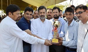 Minister for Sports, Imran Raza Ansari presenting trophy to winners of school level water sports compeitition in Srinagar.