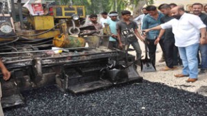 Minister for Social Welfare, Bali Bhagat during re-surfacing of road in Jammu on Monday.