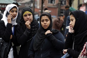 College girls stand on a road near Clock Tower  main Lal Chowk in Srinagar  after vacating their  college, office buildings following an earthquake in Srinagar on Monday. —Excelsior/Amin War