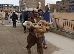 A man carries a boy, who was injured in an earthquake, at the Lady Reading hospital in Peshawar, Pakistan on Monday.(UNI)