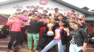 Judokas of Jammu district holding trophies and showing victory signs while posing for a group photograph after clinching Judo titles in Srinagar.