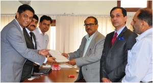 DyCM, Dr Nirmal Singh and officials of M/s Shapoorji exchanging papers during a meeting at Srinagar on Tuesday. 