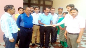 Officials presenting cheque to Khushi Ram for treatment of his ailing son.