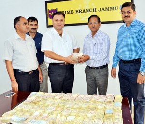 SSP Crime Jammu, Mubassir Latifi handing over recovered money to complainant in fraud case.