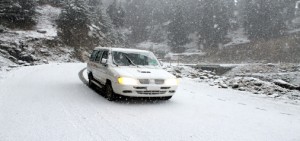 A vehicle moves on Mughal road amid snowfall on Thursday. -Excelsior/Younis Khaliq