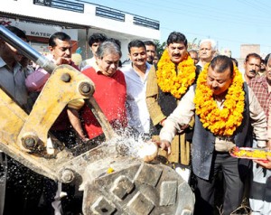 Minister for Industries, Chander Parkash Ganga flanked by MP, Jugal Kishore Sharma launching construction of drain at Dhiansar on Saturday.