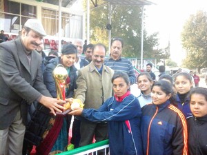 Winners of State Handball Championship being presented trophy by Minister for Law, Basharat Bukhari in Baramulla on Saturday. 