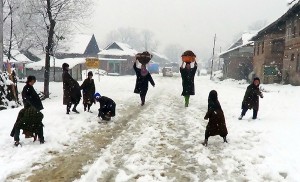After fresh snowfall women carrying dry cow-dung at village Heerpora on Mughal Road in Shopian district on Thursday. — Excelsior/Younis Khaliq