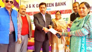 Chairman JKGB distributing credit cheques among beneficiaries during an awareness programme on Thursday.