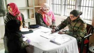 An Army doctor prescribing medicines to a patient during a medical camp at Village Gosain-Nar in Pampore.