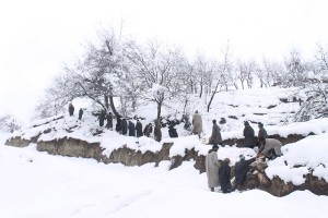 People help each other to climb a snow covered hillock at Abhama in Pulwama on Friday. — Excelsior/ Younis Khaliq