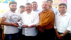 Minister for Industries and Commerce Chander Prakash Ganga awarding a winner of ‘Holi Ke Rang Upharo Ke Sang’ lucky draw.