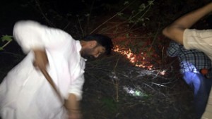 Minister for Forest, Ch Lal Singh participating in overnight fire control operations at Jammu on Monday.