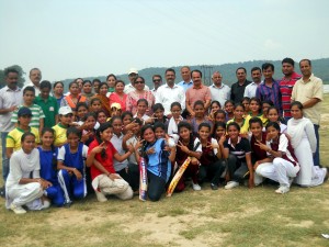 Winning girls cricket team posing with officials.
