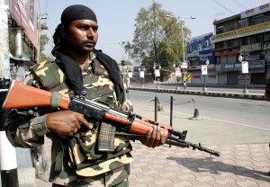 A security jawan stands guard during curfew to prevent separatist march at Lal Chowk in Srinagar on Friday.  —Excelsior/Shakeel