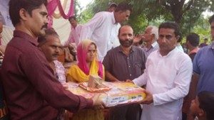 MLA Kathua Rajiv Jasrotia distributing LPG stoves among BPL women at Kathua on Friday.