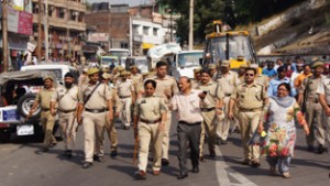 Police escorting JMC officials during anti encroachment drive in Jammu on Friday. 