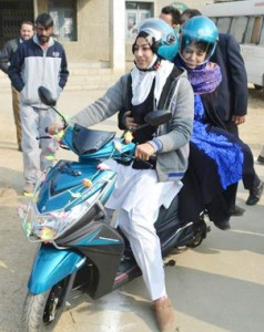 Chief Minister Mehbooba Mufti takes a scooty ride after distributing scooties among college students at Anantnag on Sunday. — Excelsior/Sajad Dar