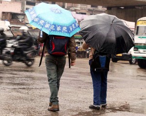 Braving heavy rain, two men with umbrellas moving through a road in Jammu on Wednesday. —Excelsior/Rakesh