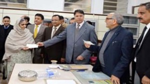 Judges of the High Court presenting a cheque to a beneficiary during a National Lok Adalat at High Court Jammu on Saturday.