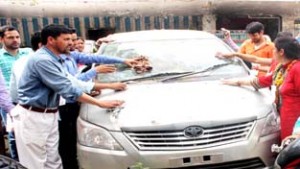 Agitating Contractual Lecturers cleaning a vehicle as token protest.-Excelsior/Rakesh