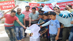 Contractual lecturers setting their degrees on fire during chain hunger strike at Jammu on Saturday.-Excelsior/Rakesh
